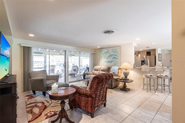 living area with recessed lighting, visible vents, and light tile patterned flooring