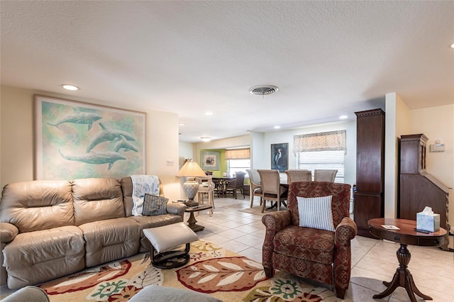 living room featuring recessed lighting, visible vents, a textured ceiling, and light tile patterned flooring
