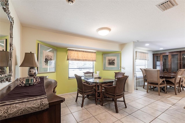 dining space featuring baseboards, visible vents, light tile patterned flooring, a textured ceiling, and recessed lighting