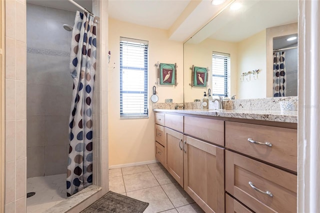 full bath with a stall shower, vanity, baseboards, and tile patterned floors