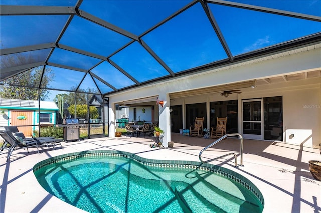 outdoor pool featuring ceiling fan, a patio, and glass enclosure
