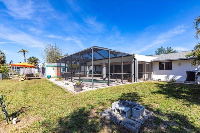 rear view of house with an outbuilding, a lawn, glass enclosure, a shed, and an outdoor pool