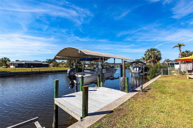 dock area with a water view, a yard, and boat lift
