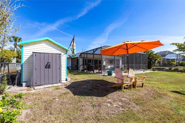view of yard featuring an outbuilding, a shed, and a lanai