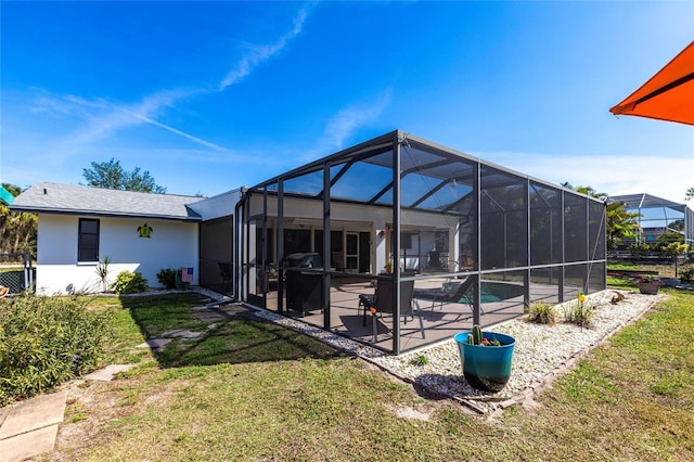 back of property with a lanai, a lawn, stucco siding, an outdoor pool, and a patio area