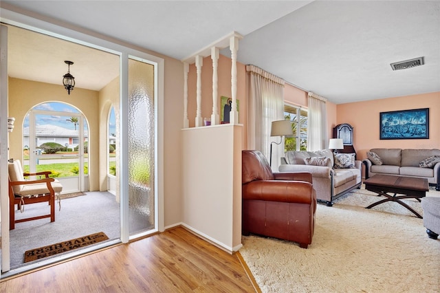 interior space featuring baseboards, light wood-style flooring, visible vents, and a healthy amount of sunlight