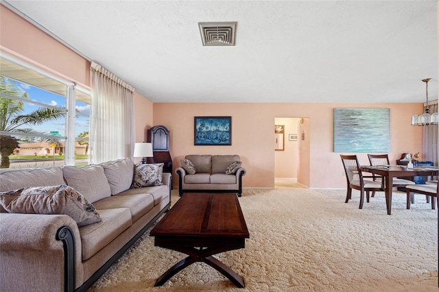 living area featuring light carpet, baseboards, visible vents, and a textured ceiling