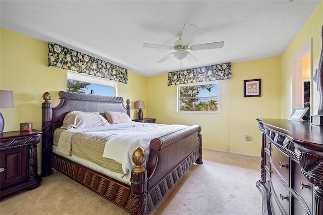 bedroom with light carpet, baseboards, and a ceiling fan