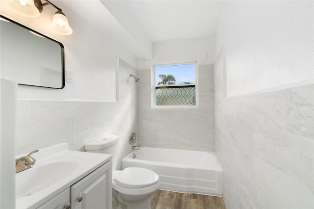 23475 Harper Ave, Port Charlotte, FL 33980 - full bath featuring tile walls, toilet, vanity, wood finished floors, and shower / tub combination