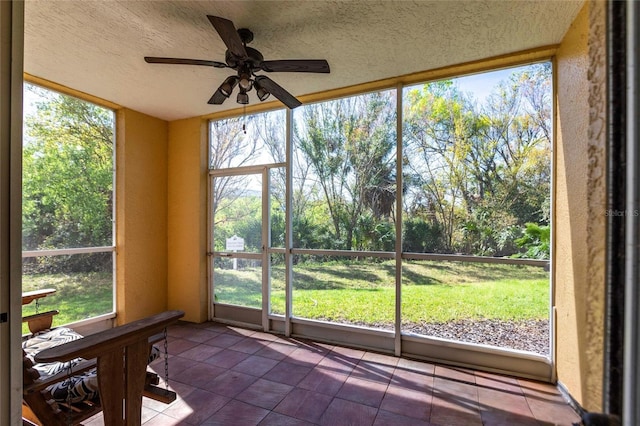 unfurnished sunroom with ceiling fan