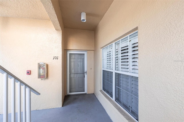 entrance to property with a balcony and stucco siding