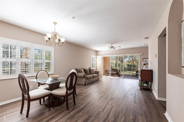 dining room with a textured ceiling, dark wood-style flooring, visible vents, and baseboards