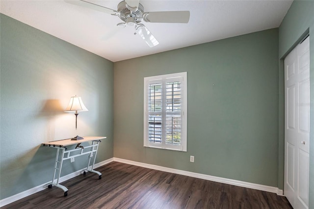 office space with dark wood finished floors, a ceiling fan, and baseboards