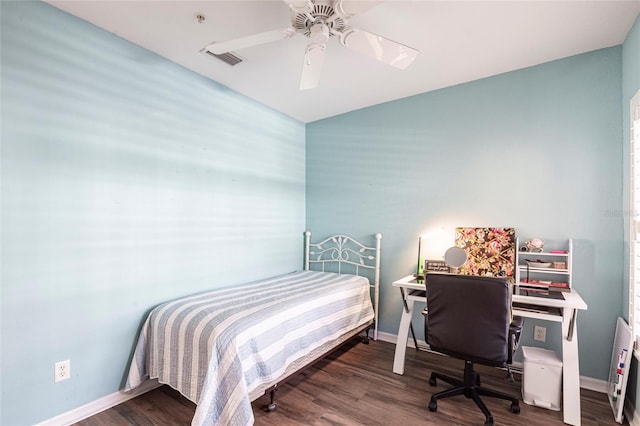 bedroom with baseboards, visible vents, and wood finished floors