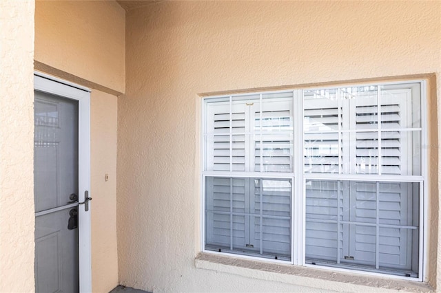 doorway to property featuring stucco siding