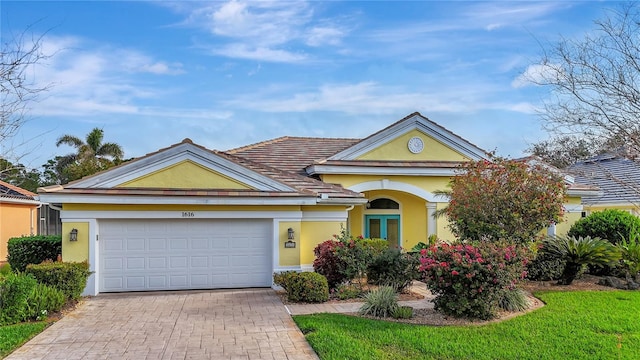 view of front of house featuring an attached garage, decorative driveway, and stucco siding