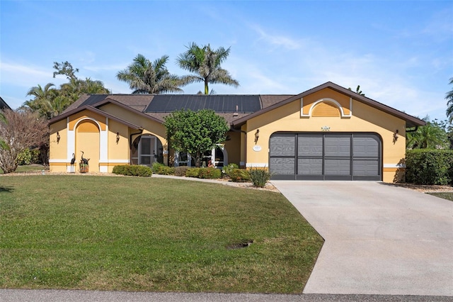 view of front of property with driveway, a garage, roof mounted solar panels, a front lawn, and stucco siding