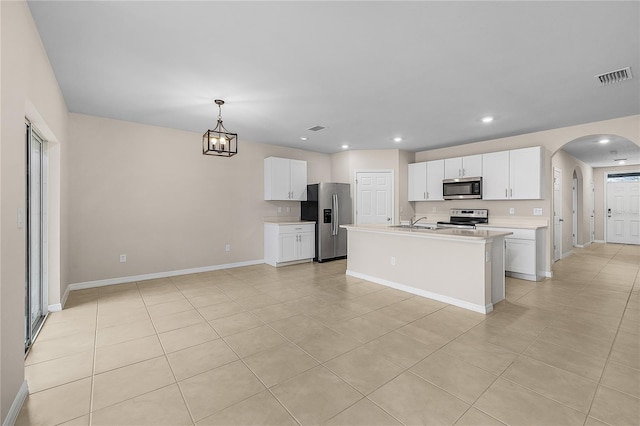 kitchen with visible vents, stainless steel appliances, arched walkways, and light countertops