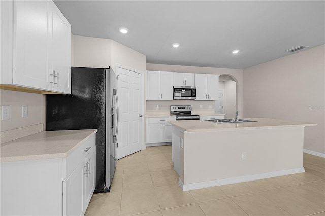 kitchen with arched walkways, a sink, visible vents, white cabinetry, and appliances with stainless steel finishes