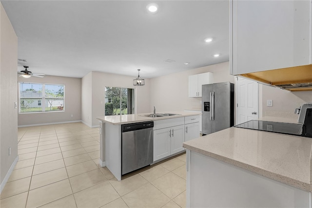 kitchen featuring light tile patterned floors, appliances with stainless steel finishes, a sink, and white cabinetry