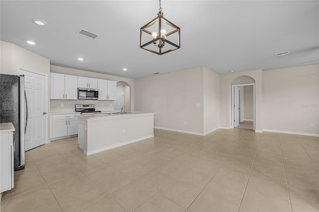 kitchen with appliances with stainless steel finishes, arched walkways, visible vents, and a sink