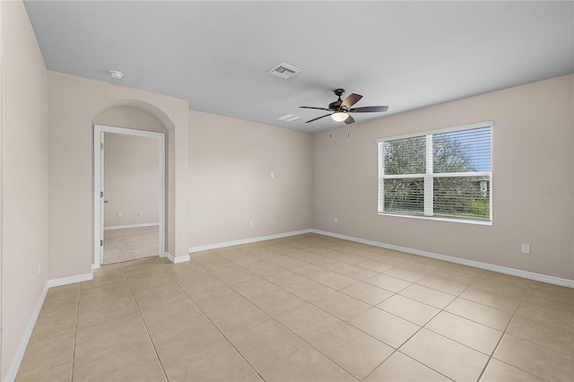 spare room with ceiling fan, visible vents, baseboards, and light tile patterned flooring