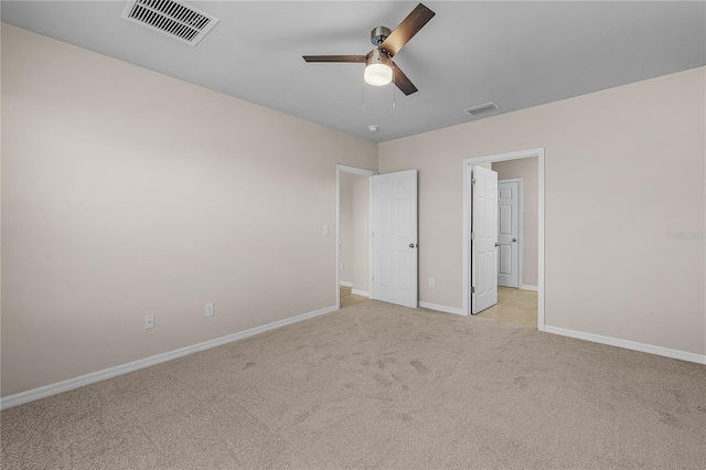 unfurnished bedroom featuring a ceiling fan, light colored carpet, visible vents, and baseboards