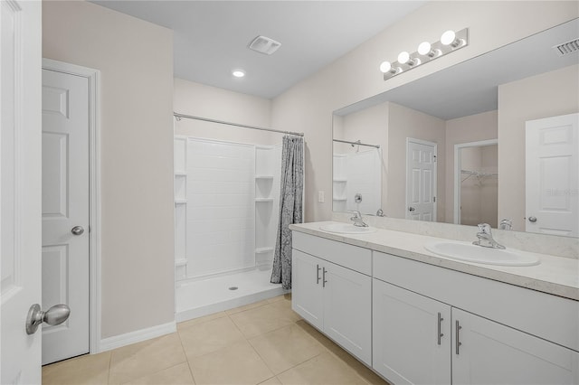 bathroom with visible vents, a sink, a shower stall, and tile patterned floors