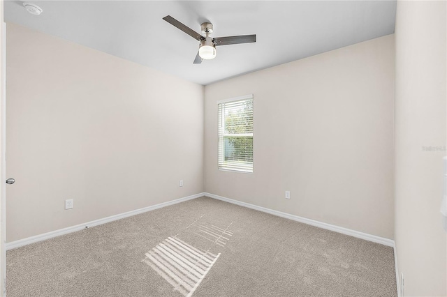 carpeted empty room featuring ceiling fan and baseboards