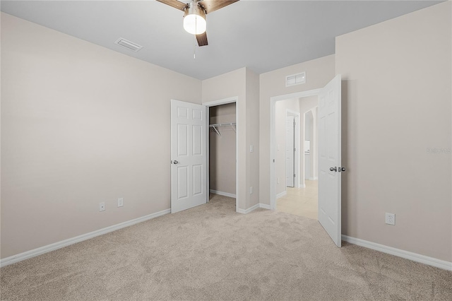 unfurnished bedroom featuring a closet, light colored carpet, visible vents, and baseboards