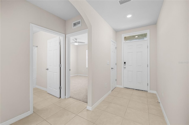 entrance foyer with arched walkways, light tile patterned flooring, visible vents, and baseboards