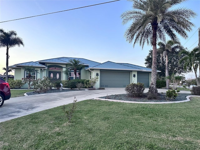 view of front of home with a standing seam roof, a front lawn, concrete driveway, an attached garage, and stucco siding