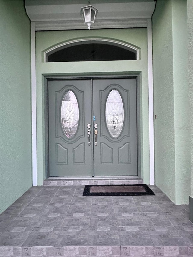 entrance to property featuring stucco siding