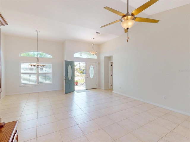 interior space featuring high vaulted ceiling, light tile patterned flooring, visible vents, and baseboards