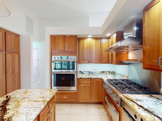 kitchen with light stone counters, light tile patterned floors, visible vents, appliances with stainless steel finishes, and wall chimney range hood