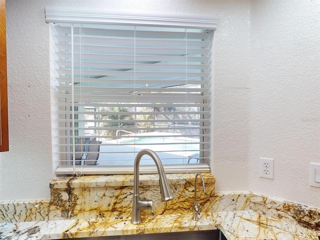 details with a sink and a textured wall