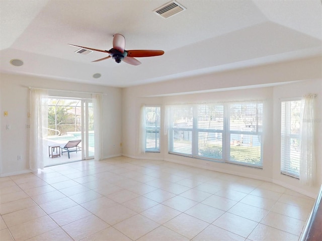 empty room with visible vents, ceiling fan, baseboards, and light tile patterned flooring