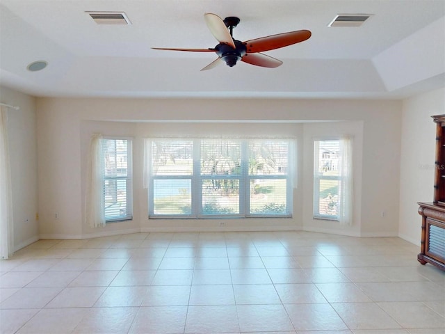 unfurnished living room with a raised ceiling, visible vents, and light tile patterned flooring