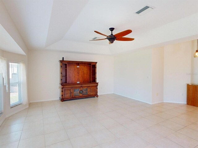 spare room featuring a tray ceiling, visible vents, ceiling fan, and baseboards