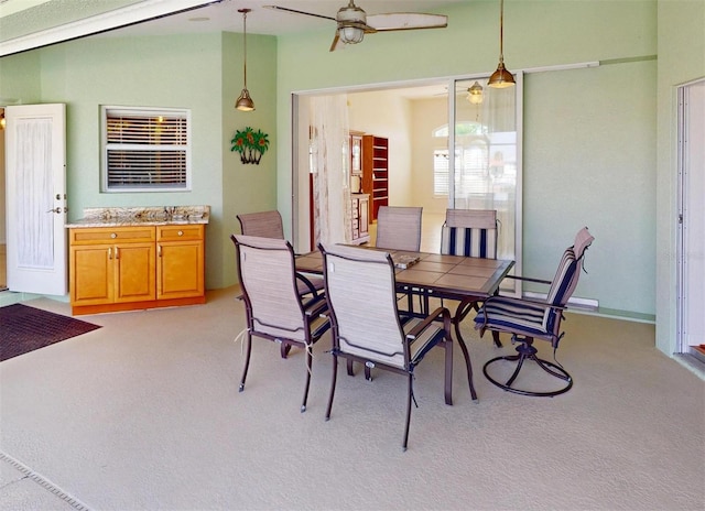 dining area featuring light colored carpet and ceiling fan