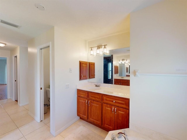 bathroom featuring baseboards, vanity, visible vents, and tile patterned floors