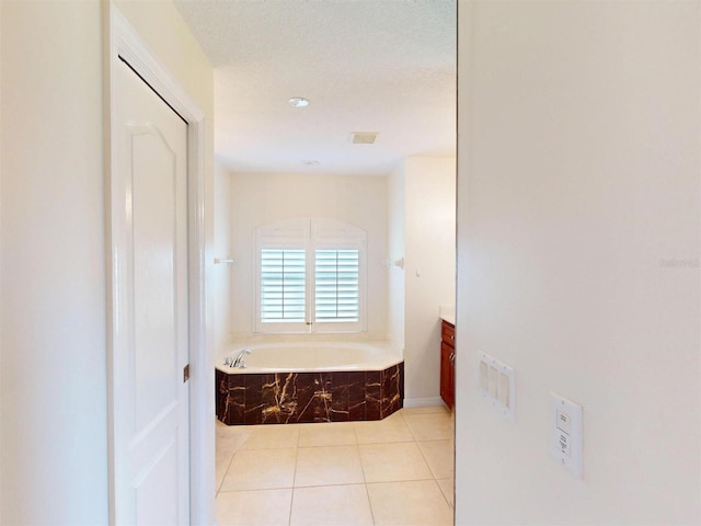 full bathroom with vanity, visible vents, a bath, and tile patterned floors