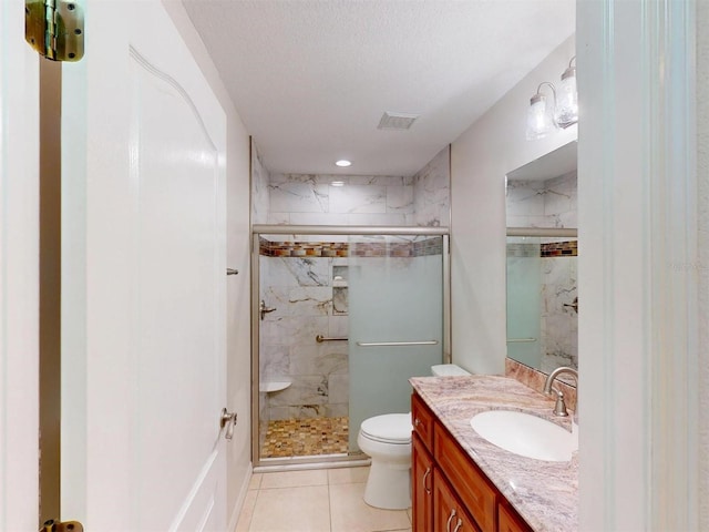 full bathroom with visible vents, vanity, a marble finish shower, and toilet