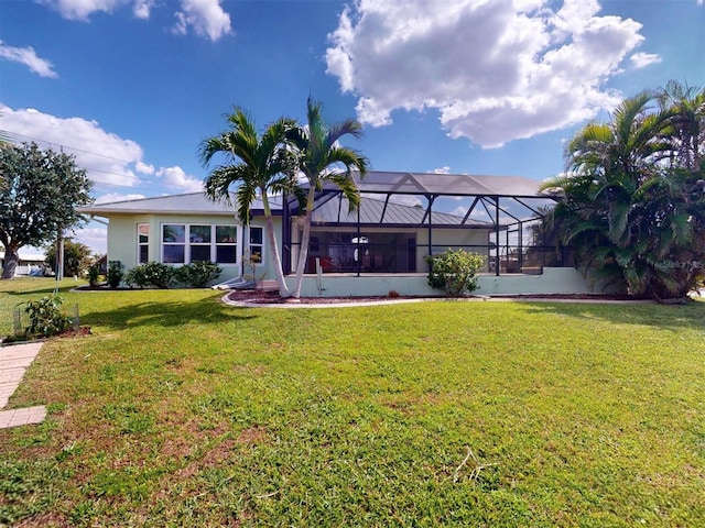 back of property featuring a lanai, a lawn, and stucco siding