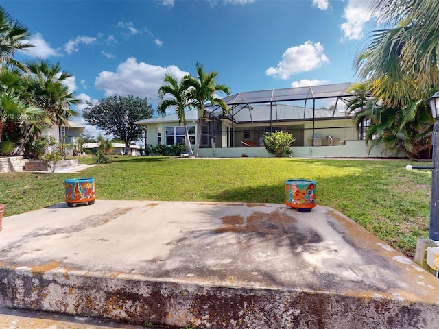 rear view of house featuring a lanai and a yard