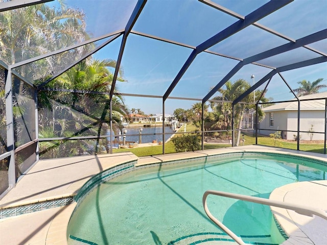 outdoor pool with glass enclosure, a patio, and a water view