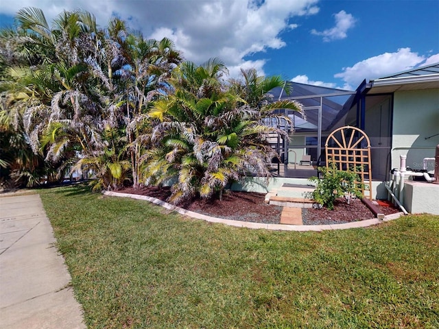 view of home's exterior featuring glass enclosure, a lawn, and a patio