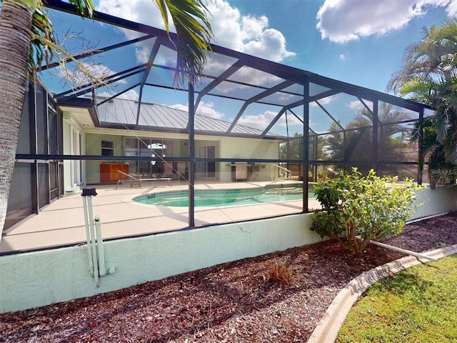 pool with glass enclosure and a patio area