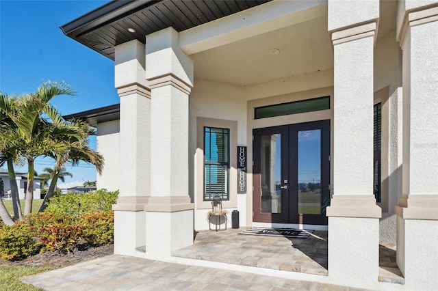 doorway to property featuring stucco siding and french doors