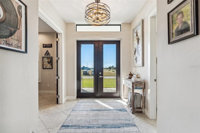 doorway to outside with french doors, baseboards, and light tile patterned floors